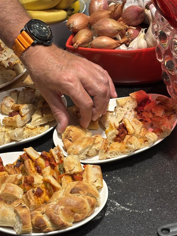Hände greifen nach verschiedenen herzhaften Snacks.