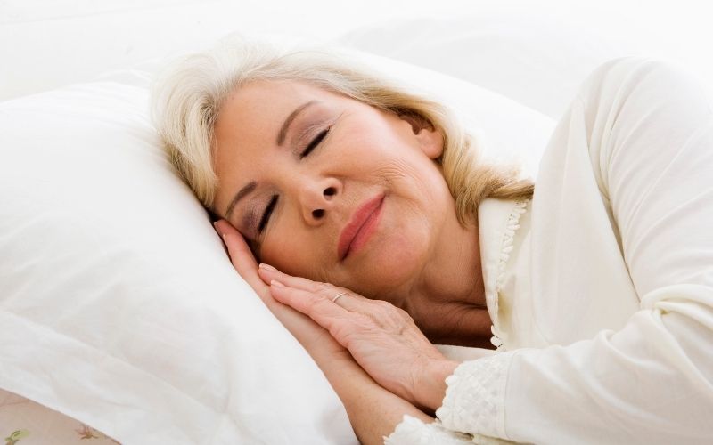 Ältere Frau schläft friedlich im Bett.