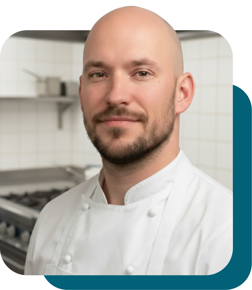 Koch in weißer Uniform, freundlich lächeln